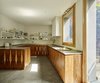 Modern home with Kitchen, Ceramic Tile Floor, Ceiling Lighting, Wood Cabinet, White Cabinet, and Drop In Sink. Creueta House-Kitchen. Photo 9 of Creueta House