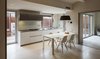 Modern home with Kitchen, Wall Lighting, White Cabinet, Stone Counter, Light Hardwood Floor, Ceiling Lighting, Cooktops, Undermount Sink, and Glass Tile Backsplashe. Duplex in Gracia-open kitchen Photo 5 of Duplex in Gracia