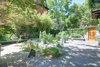Modern home with Outdoor, Side Yard, Trees, Hardscapes, Stone Patio, Porch, Deck, Pavers Patio, Porch, Deck, and Stone Fences, Wall. Lush and private courtyard perfect for entertaining and relaxing Photo 7 of The Hill Gowdy House