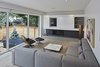 Modern home with Living Room, Sofa, Ceiling Lighting, Floor Lighting, Coffee Tables, Light Hardwood Floor, Ribbon Fireplace, and Gas Burning Fireplace. Fireplace and media centre with sliding panel Photo 5 of Brennan Avenue Residence