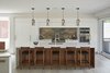 Modern home with Kitchen, Refrigerator, Wall Oven, Range, Engineered Quartz Counter, White Cabinet, Light Hardwood Floor, Stone Slab Backsplashe, Pendant Lighting, and Undermount Sink. Kitchen Photo 6 of Brennan Avenue Residence