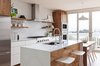 Modern home with Kitchen, Refrigerator, Wall Oven, Range, Range Hood, Engineered Quartz Counter, White Cabinet, Wood Cabinet, Laminate Cabinet, Undermount Sink, Light Hardwood Floor, Ceramic Tile Backsplashe, Pendant Lighting, and Recessed Lighting. Floating shelves with integrated LED lighting provide open storage and illuminate the workspace below. Photo 5 of Los Palmos