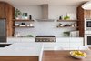 Modern home with Kitchen, Refrigerator, Wall Oven, Range, Range Hood, Engineered Quartz Counter, White Cabinet, Wood Cabinet, Laminate Cabinet, Ceramic Tile Backsplashe, Pendant Lighting, Recessed Lighting, and Undermount Sink. The Heath Ceramics wall tile backsplash was extended to full height and behind floating shelves to add texture and character to the minimal kitchen. Photo of Los Palmos