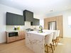 Modern home with Kitchen, Medium Hardwood Floor, Ceiling Lighting, Refrigerator, Range, Microwave, Engineered Quartz Counter, Wood Cabinet, Undermount Sink, and Dishwasher. Silestone Dekton countertops, a waterfall island and Bertazzoni appliance package. Photo of Stacks Modern