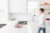 Modern home with Kitchen, White Cabinet, Refrigerator, Dishwasher, Marble Counter, Range, Range Hood, Undermount Sink, Engineered Quartz Counter, Light Hardwood Floor, and Stone Slab Backsplashe. kitchen refresh Photo 6 of Roanoke Park Residence