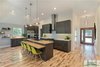 Modern home with Kitchen, Range Hood, Microwave, Refrigerator, Range, Wood Counter, Wood Cabinet, Light Hardwood Floor, Porcelain Tile Backsplashe, Engineered Quartz Counter, Recessed Lighting, and Pendant Lighting. The new kitchen with a raised ceiling. The counters are white quartz and white oak butcher block. The lighting is IKEA as well as the hardware. The backsplash are grey oversized subway tile for a casual look. Photo 7 of The Vickery Home