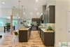Modern home with Kitchen, Dishwasher, Refrigerator, Range, Engineered Quartz Counter, Wood Counter, Wood Cabinet, Light Hardwood Floor, Range Hood, Porcelain Tile Backsplashe, and Recessed Lighting. In the foreground, the two drawer dishwasher which allows small loads to be run with less water consumption. Photo 8 of The Vickery Home