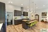 Modern home with Kitchen, Refrigerator, Range Hood, Range, Wood Cabinet, Light Hardwood Floor, Porcelain Tile Backsplashe, Engineered Quartz Counter, and Recessed Lighting. Most of the artwork throughout the home is created by the wife. Photo 10 of The Vickery Home