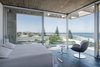 Modern home with Bedroom, Chair, Bed, Ceiling Lighting, and Dark Hardwood Floor. Corner Bedroom Photo 8 of La Iluminada
