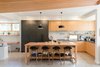 Modern home with Kitchen, Refrigerator, Cooktops, Range Hood, Wood Counter, Laminate Cabinet, Wood Cabinet, Concrete Floor, Stone Counter, Ceramic Tile Backsplashe, Ceiling Lighting, and Undermount Sink. Kitchen Photo 13 of The North Bridge Residence