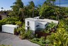 Modern home with Exterior, Beach House Building Type, and Wood Siding Material. Aerial view from the back of the property looking over the 2bed/2bath main house, art studio, and 1bed/1bath detached Ohana and mature apple banana, mango and palm trees Photo of A Modern 1954 Plantation Style Home on Maui