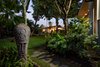 Modern home with Outdoor, Trees, Grass, Gardens, Flowers, Walkways, Landscape Lighting, and Hanging Lighting. Front entrance with Tahitian statue and volcano rock pavers Photo 11 of A Modern 1954 Plantation Style Home on Maui