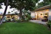 Modern home with Exterior, House Building Type, Beach House Building Type, Shingles Roof Material, Metal Siding Material, Wood Siding Material, and Flat RoofLine. View of the Main house and Ohana from the front yard Photo 17 of A Modern 1954 Plantation Style Home on Maui