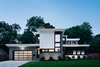 Modern home with Exterior, House Building Type, Metal Siding Material, Stucco Siding Material, and Flat RoofLine. Street facade, presenting a relatively closed face, with higher transoms windows to still afford a sense of air and sky from the inside while blocking unwanted, penetrating views from the street. Photo of Roslyn Road Residence