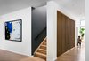 Modern home with Staircase, Wood Tread, and Metal Railing. Stairway with custom slat wall to give a hint of the stair beyond, while eliminating the need for extravagant, unwanted visual clutter of a railing. Photo 7 of Roslyn Road Residence