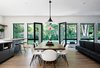Modern home with Dining Room, Chair, Table, Stools, Ceiling Lighting, Pendant Lighting, and Light Hardwood Floor. Dining area overlooking rear yard Photo 9 of Roslyn Road Residence