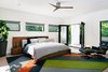 Modern home with Ceiling Lighting, Pendant Lighting, Chair, and Light Hardwood Floor. Master bedroom, with rear-facing balcony overlooking the pool beyond. Photo 12 of Roslyn Road Residence