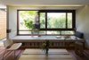 Modern home with Living Room, Bench, Coffee Tables, Stools, Storage, Recessed Lighting, Bookcase, Medium Hardwood Floor, and Ceiling Lighting. Living room window connection with orchard beyond. Photo 4 of Kihilla