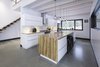 Modern home with Kitchen, Wood Counter, White Cabinet, Wood Cabinet, Concrete Floor, Ceramic Tile Backsplashe, Pendant Lighting, Recessed Lighting, and Drop In Sink. Kitchen, all wood finishes was taken from the forest. Photo 12 of Maison Lac Brûlé