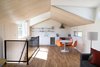 Modern home with Kitchen, Refrigerator, Wall Oven, Cooktops, Engineered Quartz Counter, White Cabinet, Medium Hardwood Floor, Ceiling Lighting, Accent Lighting, and Undermount Sink. Modern kitchen with a minimal palette Photo 3 of Division Street ADU