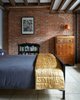 Modern home with Bedroom, Bed, Shelves, Bookcase, and Travertine Floor. As architects AND engineers, we expose structure wherever possible. The original wood joists are exposed in the bedroom. Photo 6 of Williamsburg Rowhouse