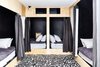 Modern home with Bedroom, Storage, Bed, and Ceiling Lighting. Bunk room in basement with custom artwork on floor by Sean Martorana. Curtains by West Elm. Photo 11 of Lokal A-Frame