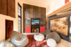 Modern home with Living Room, Chair, Ottomans, Accent Lighting, and Concrete Floor. A custom fireplace and media cabinet fabricated from raw steel is recessed into a wall of reclaimed wood planks from a deconstructed building outside Vancouver, BC.
The wood burning fireplace is somewhat contrary to “sustainable” design, however, with winter winds downing trees there is an abundant supply of firewood and an occasional winter fire is enjoyed! Photo 4 of The Barn Gallery