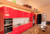 Modern home with Kitchen, Refrigerator, Cooktops, Wall Oven, Range Hood, Microwave, Dishwasher, Tile Counter, Colorful Cabinet, Concrete Floor, Porcelain Tile Backsplashe, Recessed Lighting, and Accent Lighting. The kitchen is seriously hacked IKEA with Semi-handmade door and drawer fronts. The backsplash is Fossil porcelain tile from Refin and the counter is porcelain tile which resembles reclaimed concrete.
The over-scale pivoting front entry door crafted from VG white pine planks 3″ thick, sourced from a previous century farmers co-op building in eastern Washington. The door locks and unlocks with the touch of your smart phone. Photo 6 of The Barn Gallery