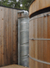 Modern home with Outdoor, Front Yard, and Landscape Lighting. The rain catchment pre-filtration tower filters the rain water from the roof of particulates before it supplies the storage tank. The first flush filtration system is hidden inside the recycled culvert. It is displayed prominently next to the storage tank near the Barn Gallery entrance. Photo 10 of The Barn Gallery