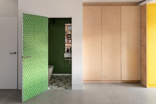 A bright green, patterned wallpaper envelops the bathroom on the lower level.