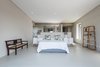 Modern home with Bedroom, Bed, Storage, Concrete Floor, Ceiling Lighting, Night Stands, and Shelves. A low wall separates the main bedroom sleeping area from the bathroom, creating an open plan effect, and affording views even from the bathroom. Photo 6 of City View House