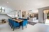Modern home with Dining Room, Ceiling Lighting, Porcelain Tile Floor, Chair, and Table. Ascending the staircase to the upper level, a corner window at the staircase gives a glimpse to the nature reserve. Photo 7 of City View House