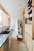 Modern home with Kitchen, Refrigerator, Dishwasher, Microwave, Engineered Quartz Counter, Wood Cabinet, Laminate Cabinet, Concrete Floor, Ceramic Tile Backsplashe, and Recessed Lighting. Galley kitchen looking east toward broom closet and doorway to living areas Photo 3 of K Street Addition