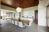 Modern home with Kitchen, Engineered Quartz Counter, Recessed Lighting, Pendant Lighting, Quartzite Counter, Undermount Sink, Glass Tile Backsplashe, White Cabinet, and Concrete Floor. kitchen and hall Photo 10 of Stouffville Residence