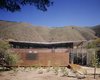 Modern home with Exterior, Butterfly RoofLine, House Building Type, Metal Siding Material, Wood Siding Material, Metal Roof Material, and Glass Siding Material. Front facade of the house Photo 3 of Jackson Family Retreat