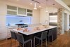 Modern home with Kitchen, Glass Tile Backsplashe, Engineered Quartz Counter, White Cabinet, Range, Refrigerator, Undermount Sink, Ceiling Lighting, Medium Hardwood Floor, Pendant Lighting, Wine Cooler, and Wood Cabinet. Modern chefs kitchen Photo 6 of New Perspective
