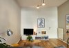 Modern home with Living Room, Coffee Tables, Ottomans, Sofa, Light Hardwood Floor, and Console Tables. After: living area Photo 9 of Young and Fresh Apartment Renovation - Brussels