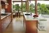 Modern home with Kitchen, Glass Tile Backsplashe, Refrigerator, Wall Oven, Cooktops, Undermount Sink, Ceiling Lighting, Light Hardwood Floor, Wood Cabinet, and Engineered Quartz Counter. View of kitchen and breakfast alcove Photo 9 of DESCHUTES House