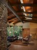 Modern home with Living Room, Sofa, Chair, Coffee Tables, Ceiling Lighting, Two-Sided Fireplace, and Terrazzo Floor. View of living area with new clerestory windows, wood paneling and casework. Photo 4 of Lake Forest Park Mid Century Renovation