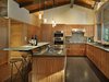 Modern home with Kitchen, Mosaic Tile Backsplashe, Wood Cabinet, Engineered Quartz Counter, Refrigerator, Cooktops, Undermount Sink, Dishwasher, Ceiling Lighting, Terrazzo Floor, and Pendant Lighting. Kitchen with custom CNC-milled textured cherry cabinets, quartz counters and cast-glass breakfast counter. Photo 7 of Lake Forest Park Mid Century Renovation