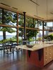 Modern home with Kitchen, Porcelain Tile Backsplashe, Pendant Lighting, Engineered Quartz Counter, Ceiling Lighting, Wall Oven, Cooktops, Refrigerator, Wood Cabinet, Dark Hardwood Floor, and Drop In Sink. Interior view of kitchen and dining spaces Photo 5 of Port Ludlow House