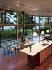Modern home with Kitchen, Porcelain Tile Backsplashe, Refrigerator, Wood Cabinet, Ceiling Lighting, Wall Oven, Drop In Sink, Cooktops, Dark Hardwood Floor, Pendant Lighting, and Engineered Quartz Counter. View of main kitchen, dining , and living spaces Photo 6 of Port Ludlow House