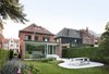 Modern home with Outdoor, Flowers, Hardscapes, Garden, Small Patio, Porch, Deck, Back Yard, Gardens, Vertical Fences, Wall, Concrete Patio, Porch, Deck, Shrubs, Trees, and Grass. New addition and patio from outdoor garden: the concrete terrace extends into the garden, and receives daylight over the house from the southern sun. Photo 8 of Leuven Residential Addition