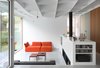 Modern home with Living Room, Concrete Floor, Ribbon Fireplace, Media Cabinet, Sectional, Sofa, Ceiling Lighting, Wood Burning Fireplace, Coffee Tables, and Shelves. Interior view West Photo of Leuven Residential Addition