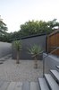 Modern home with Outdoor, Walkways, Hardscapes, Front Yard, Garden, Gardens, and Shrubs. In the entrance courtyard, two large aloes forms a green contrast to the otherwise grey color palette. Photo 7 of Grey House
