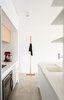 Modern home with Kitchen, Concrete Floor, Refrigerator, Cooktops, Light Hardwood Floor, Quartzite Counter, Wood Cabinet, Ceiling Lighting, and White Cabinet. Kitchen Photo 2 of Apartment Natom