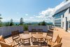 Modern home with Outdoor, Concrete Fences, Wall, Large Patio, Porch, Deck, Back Yard, Stone Fences, Wall, Stone Patio, Porch, Deck, Vertical Fences, Wall, and Trees. The outdoor patio and solar paneled roof at Grahall. Photo 2 of Grahall Estate