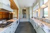 Modern home with Kitchen, Ceiling Lighting, Cooktops, Range, Range Hood, Drop In Sink, Slate Floor, Marble Counter, and White Cabinet. The kitchen's stunning marble countertops and slate floors. Photo 3 of Grahall Estate