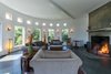Modern home with Living Room, Wall Lighting, Chair, Slate Floor, Concrete Floor, Wood Burning Fireplace, and Sofa. The circular living area features a granite fireplace. Photo 4 of Grahall Estate