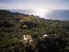 Modern home with Exterior, Curved RoofLine, Metal Roof Material, House Building Type, Wood Siding Material, and Glass Siding Material. Aerial view of the area Photo of Casa de la Tierra y el Mar